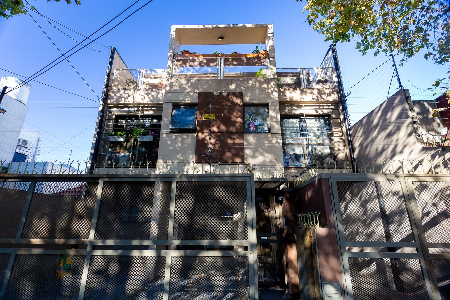 Fachada terminada de Formosa 10 desde la calle: tres niveles, terraza con pérgola, balcones con plantas y portón de reja