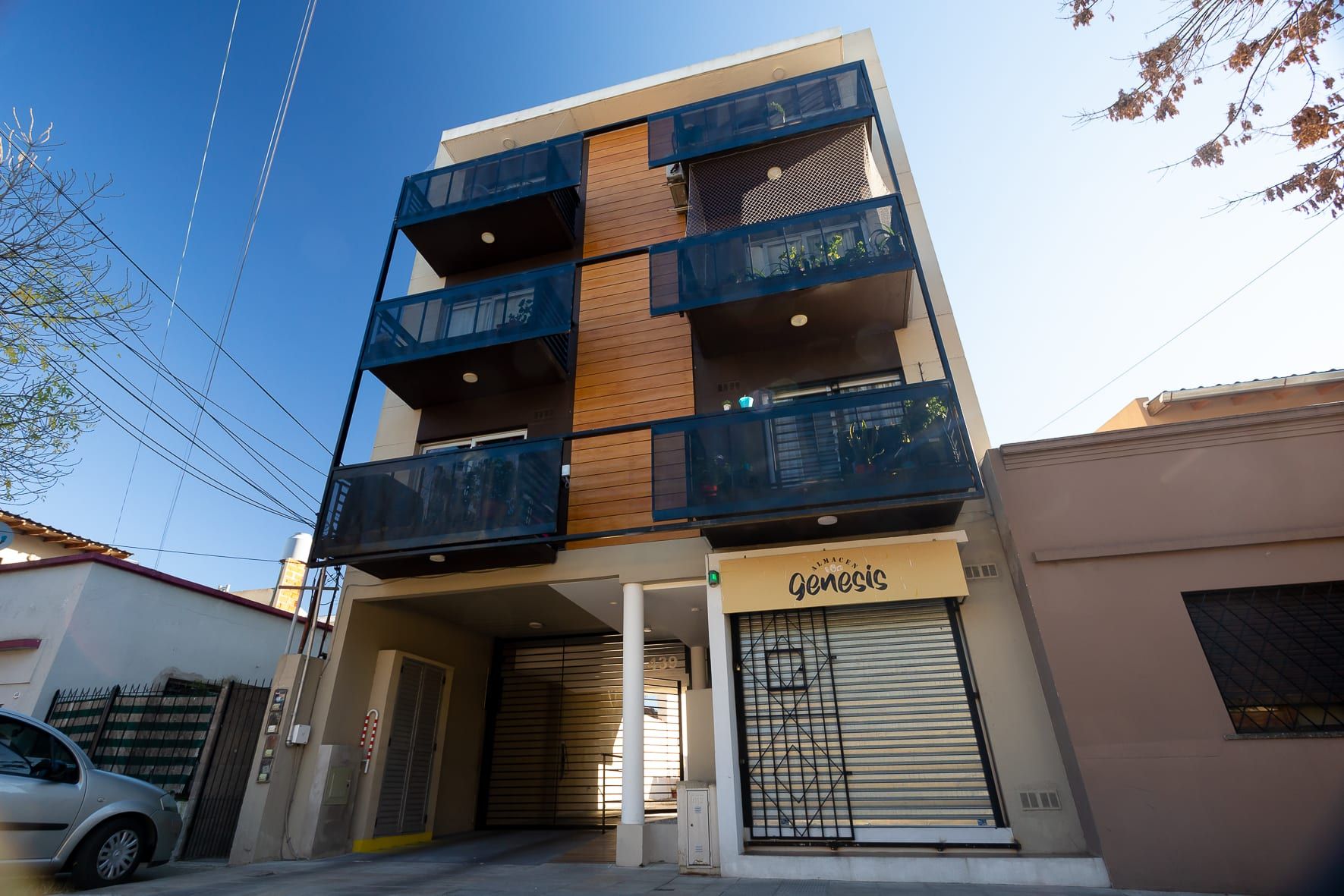 Fachada terminada de República del Líbano 439 desde la calle: balcones vidriados, madera y acceso a cocheras