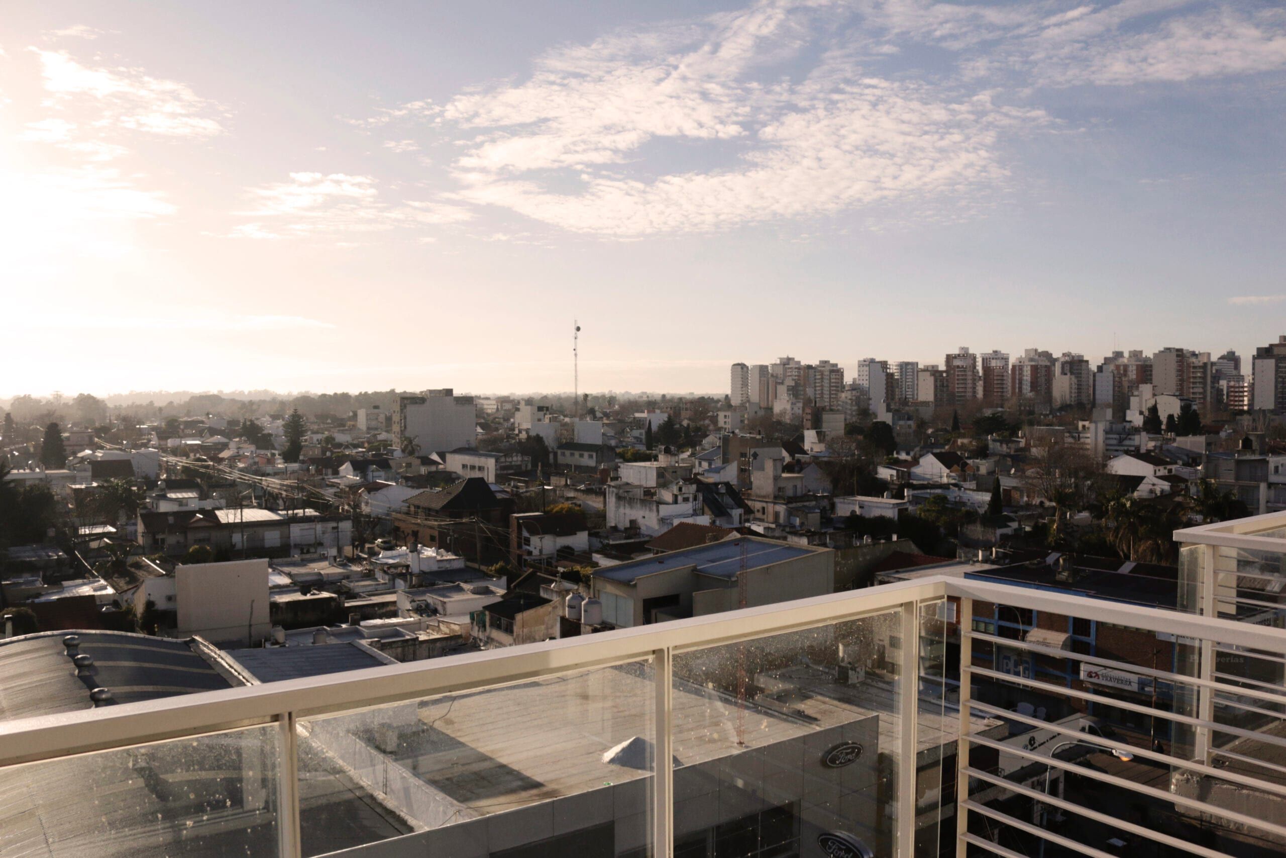 Vista panorámica de Quilmes desde una terraza con baranda de vidrio de Yrigoyen 37 al atardecer