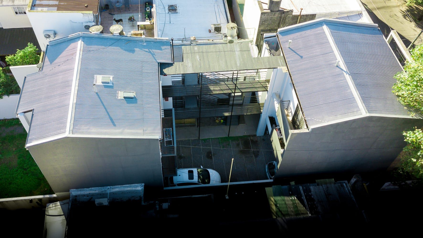 Vista aérea de Lavalle 1213: los dos bloques con techos de chapa y el patio central con cocheras y pasarelas