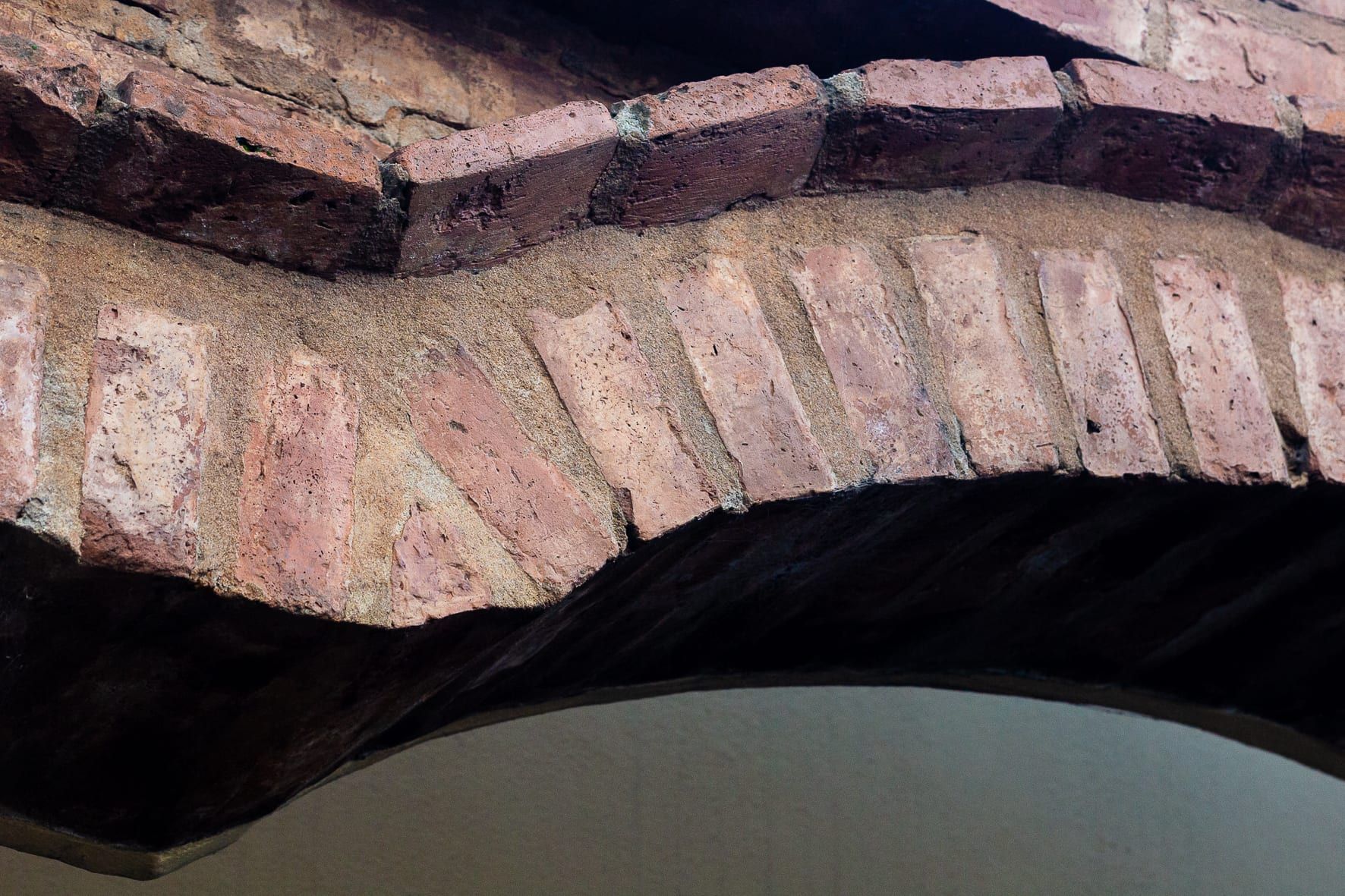 Detalle constructivo del arco de ladrillo visto sobre el acceso, con hiladas en sardinel