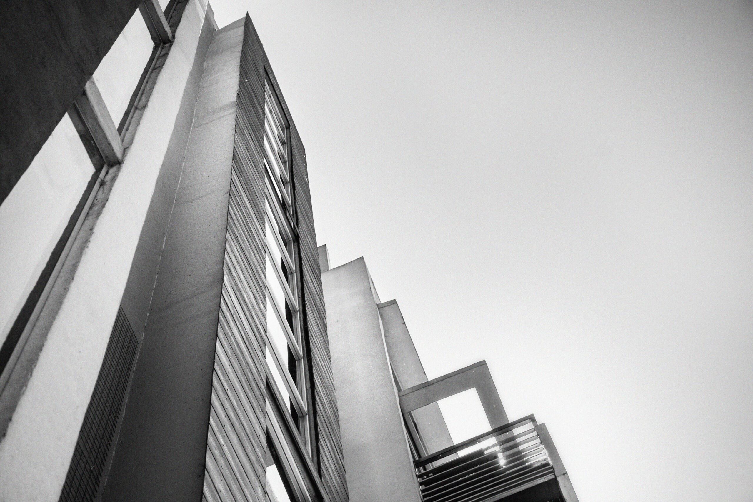 Detalle en blanco y negro de la fachada: listones de madera y balcones vistos en contrapicado