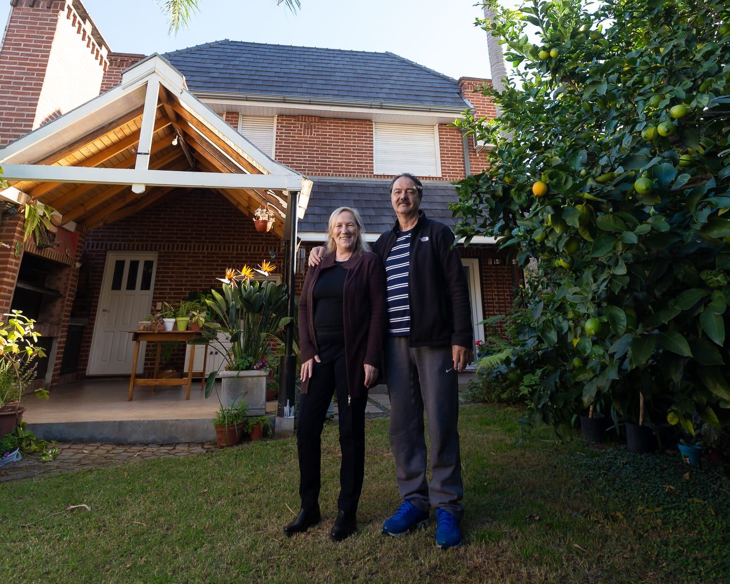 Propietarios en el jardín del contrafrente de la casa Chiclana, con galería de madera y parrilla